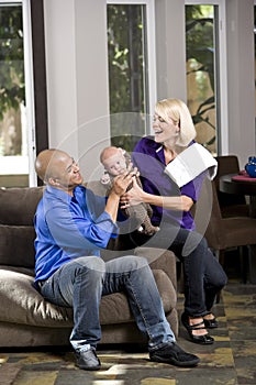 Dad handing baby to mom with burp cloth