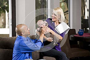 Dad handing baby to mom with burp cloth