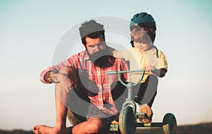 Dad help his child ride a bicycle. Lovely father teaching son riding bike.