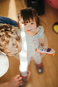 Dad helping his little daughter put on her boots