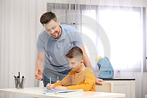 Dad helping his son with homework in room