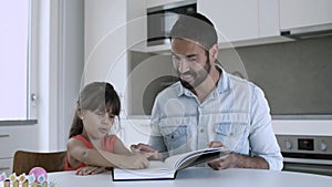 Dad helping little daughter to learn to read