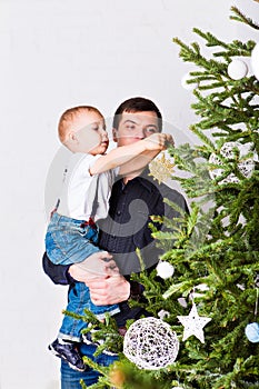 Dad helping son to decorate christmas tree