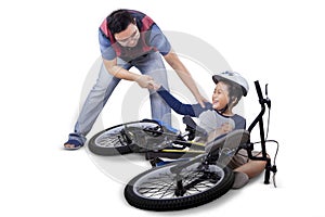 Dad helps his son after falling from bike