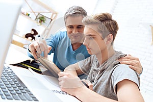 Dad helps his son learn homework.