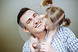 Dad and his daughter child girl are playing, smiling and hugging. Family holiday and togetherness. Shallow depth of field.