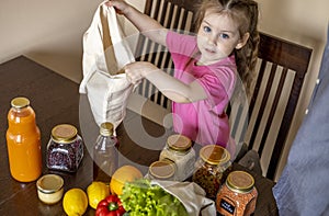 Dad and his daughter are pulling food out of the bag. Purchases from the store. Reusable package