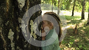 Dad and his five-year-old daughter are playing hide and seek in a forest glade