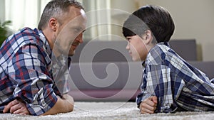 Dad and his son looking at each other and competing in force, playing game