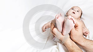 Dad is holding the baby`s tiny feet. Small baby feet on male hands close up. Happy family concept. Beautiful conceptual image of