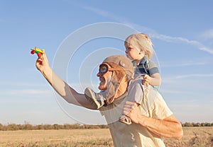 Dad holding a toy plane and plays with his little son