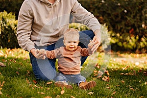 dad holds hands and plays with son on the lawn. games and walks with children.