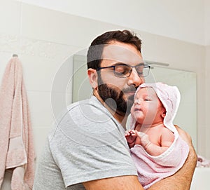 Dad holds his daughter in his arms after the first bath