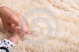 Dad holds in his hands a small baby hand. Small hand of a newborn baby in large hands of dad. Baby holds father's finger