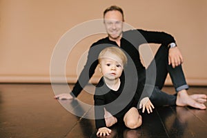 Dad holds a one-year-old daughter on a beige background. Fatherly love. Father`s day