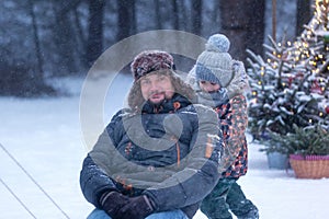 Dad and kid in winter nature. Portrait of happy father and son on winter walk. Enjoying spending time together. Family concept