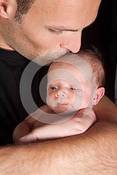 Dad kissing baby