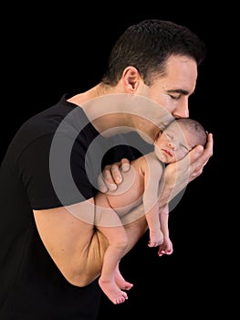 Dad kissing newborn son