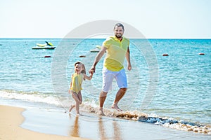 Dad and little girl play, run on the beach and fool around on the sea coast. Family vacation at sea with a child