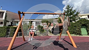 Dad with a little girl swing on swings in the playground