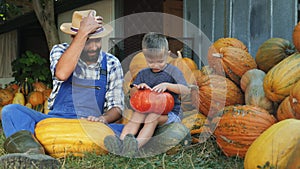 Dad and little son having fun drumming on pumpkins