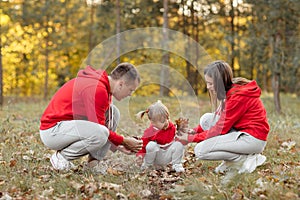 Dad, mom and little cute daughter having fun and playing in the autumn park. family concept, father`s, mother`s and baby`s day