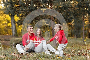 Dad, mom and little cute daughter having fun and playing in the autumn park. family concept, father`s, mother`s and baby`s day