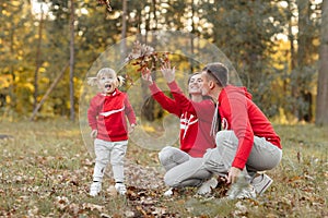 Dad, mom and little cute daughter having fun and playing in the autumn park. family concept, father`s, mother`s and baby`s day