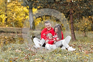 Dad, mom and little cute daughter having fun and playing in the autumn park. family concept, father`s, mother`s and baby`s day