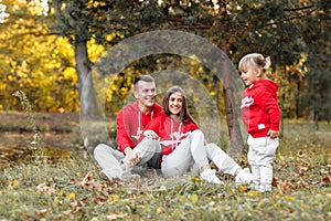 Dad, mom and little cute daughter having fun and playing in the autumn park. family concept, father`s, mother`s and baby`s day