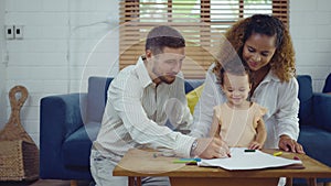 Dad, Mom and little daughter drawing with colorful pencils on paper happy smiling.Young family spend free time together in living