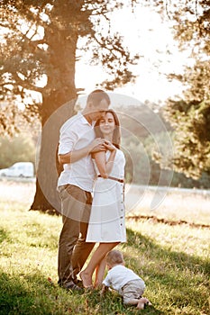 Dad, mom and little son outdoors in the park. The concept of summer holiday. Mother`s, father`s, baby`s day. Family spending ti