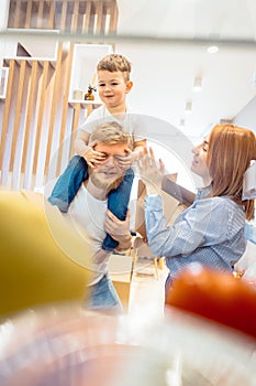 Dad mom and little son play in the bedroom with paper boxes