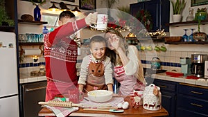 Dad, mom and son playing with dough and flour to have fun in Christmas red apron