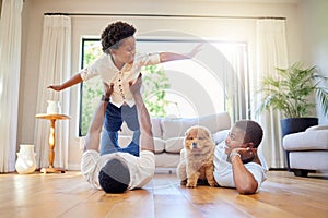 Dad, mother and home playing airplane together with happiness and puppy with smile. House, family and support of a mom