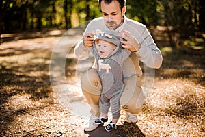 Dad picks up by hands his laughing son outdoors