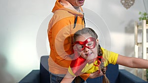 dad play superhero with his daughter. feminism a happy family a close-up home kid dream concept. superhero daughter