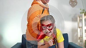 dad play superhero with his daughter. feminism a happy family a close-up home kid dream concept. superhero daughter