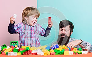 Dad play toys with kid. Dad and child build plastic blocks. Happy family. Child development and upbringing. Importance