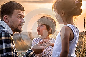 Dad playing with two little cute daughters