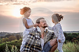 Dad playing with two little cute daughters