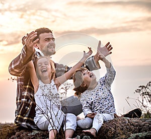 Dad playing with two little cute daughters