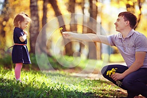 Dad plays with daughter in summer park