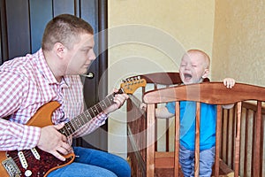 Dad plays guitar to console his crying son