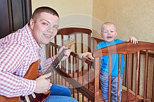 Dad plays guitar to console his crying son