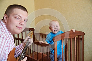 Dad plays guitar to console his crying son