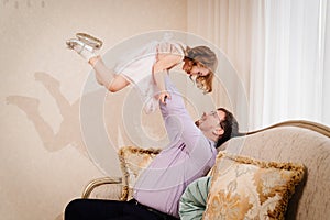 dad plays with his daughter and tosses her up. paternal love.