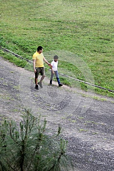 Dad plays sports together with his son, run on an outdoor track, they exercise and talk, they spend quality time with the family