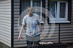 Dad is preparing a mushroom barbecue on the grill in isolation in the fresh air at the dacha.