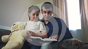 Dad reading a book to daughter in bedroom. Happy family kid dream concept. Father parent reads a book at night to his